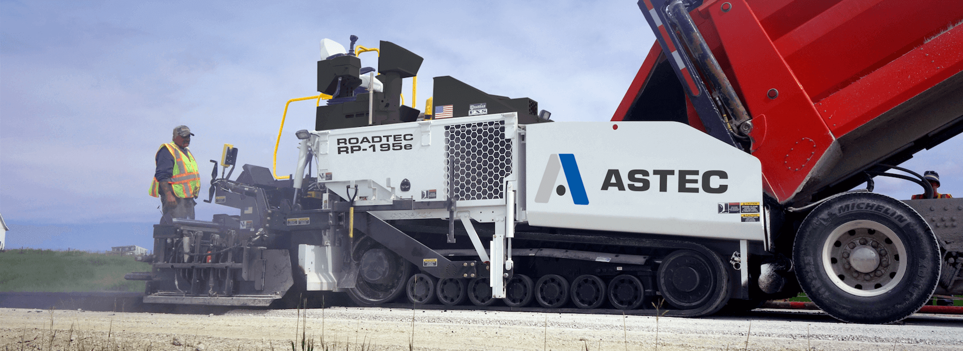 Roadtec RP-195 highway class asphalt paver paving with a dump truck